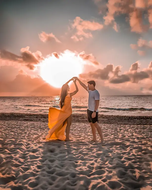 Pasangan romantis di pantai saat matahari terbenam