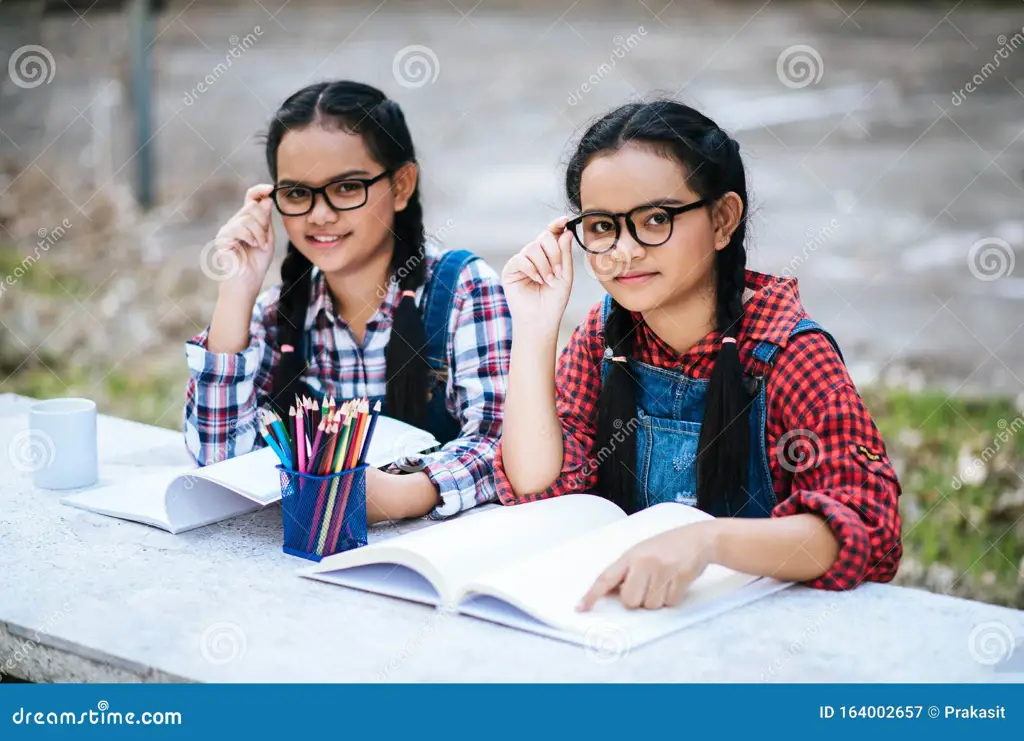 Suami istri belajar online bersama-sama dengan laptop dan buku