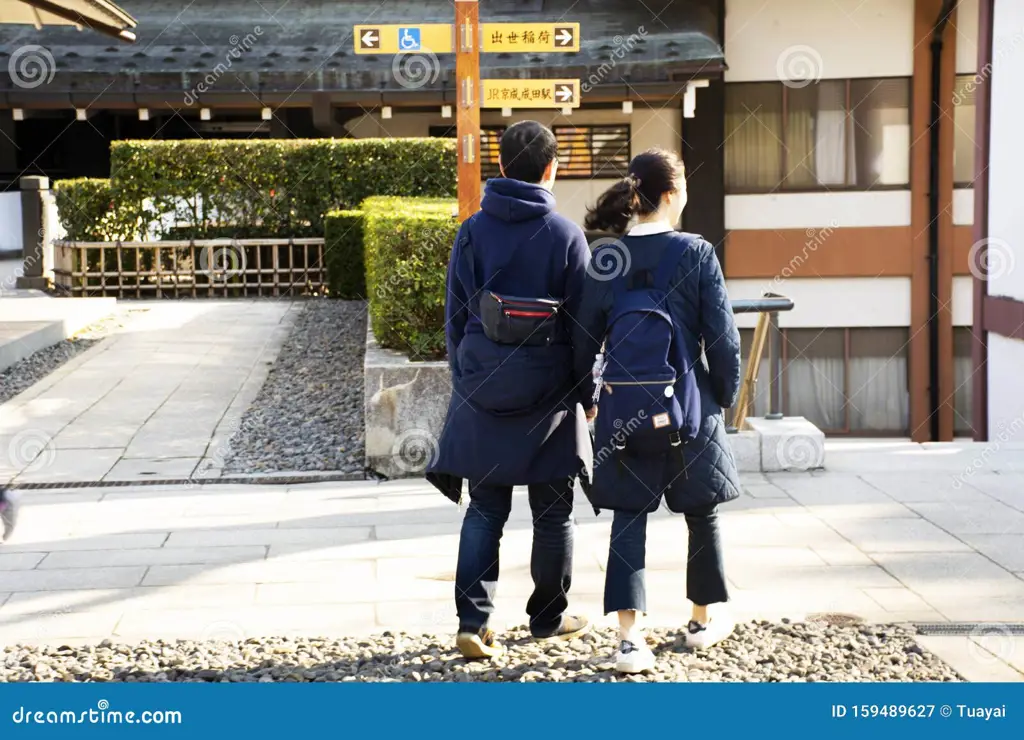 Pasangan yang bergandengan tangan berjalan-jalan di jalanan Tokyo