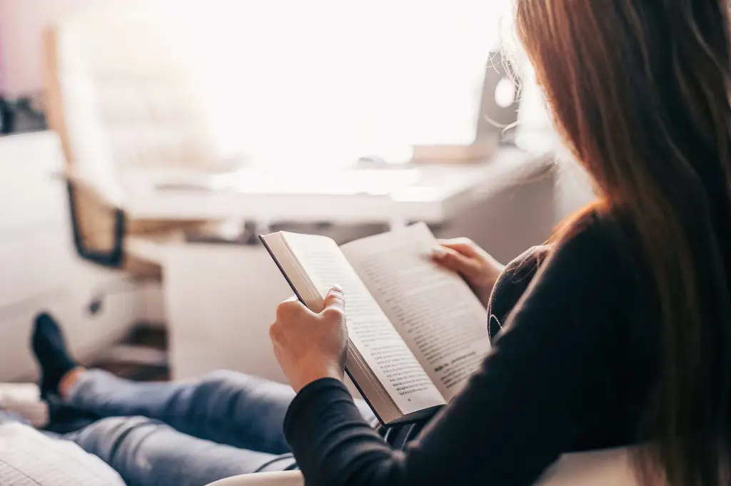 Seorang wanita membaca buku di tempat yang tenang