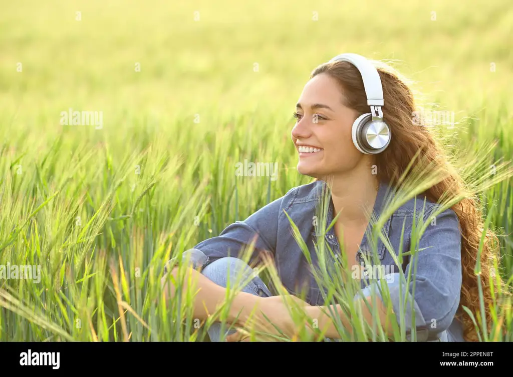 Seseorang dengan senang hati mendengarkan musik dengan headphone