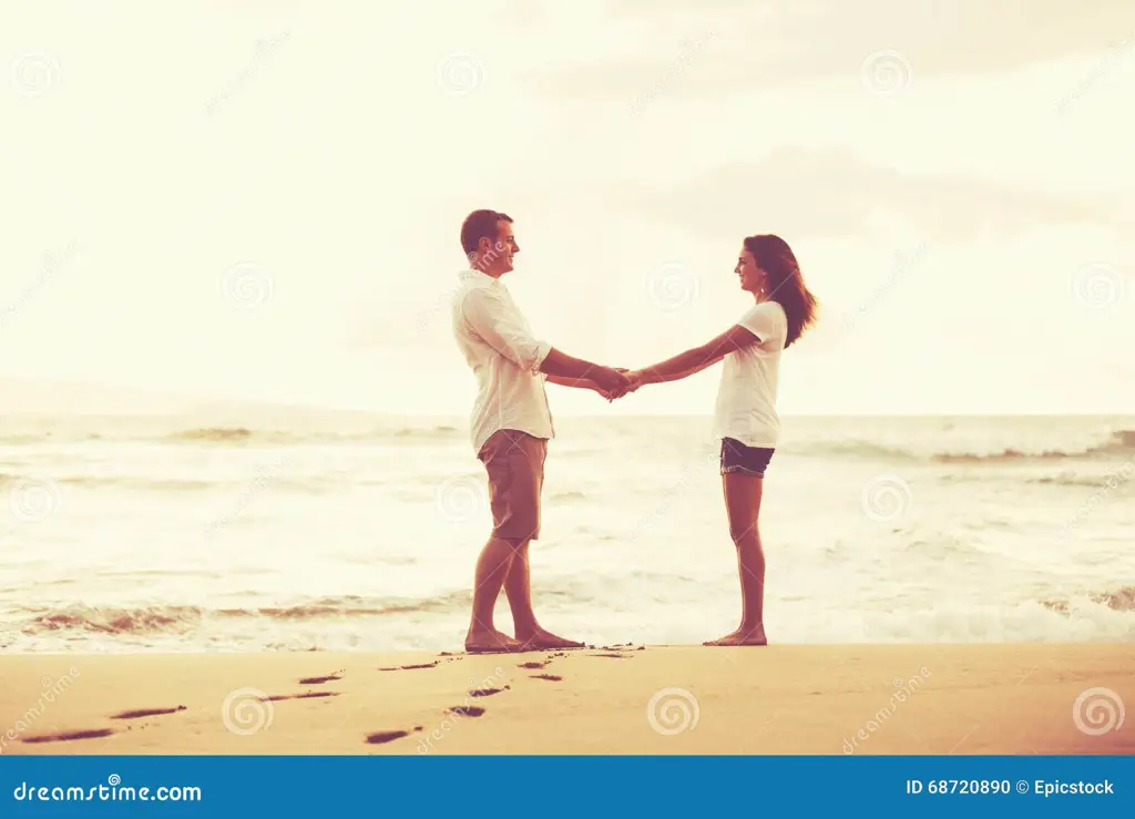 Pasangan romantis di pantai saat matahari terbenam