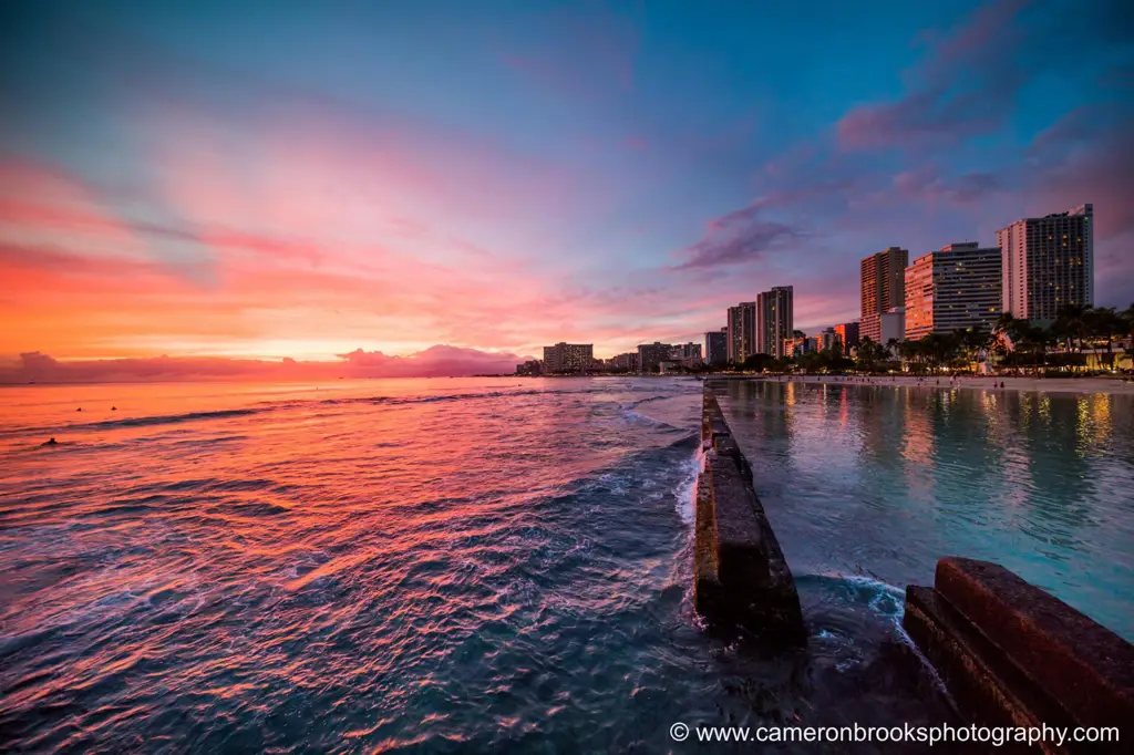 Pasangan menikmati matahari terbenam di pantai Waikiki