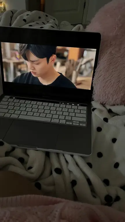 Pasangan bahagia menonton drama Korea di laptop