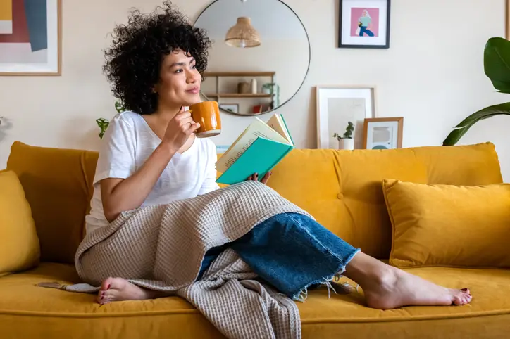 Seseorang sedang melakukan kegiatan self-care, seperti mandi air hangat atau membaca buku