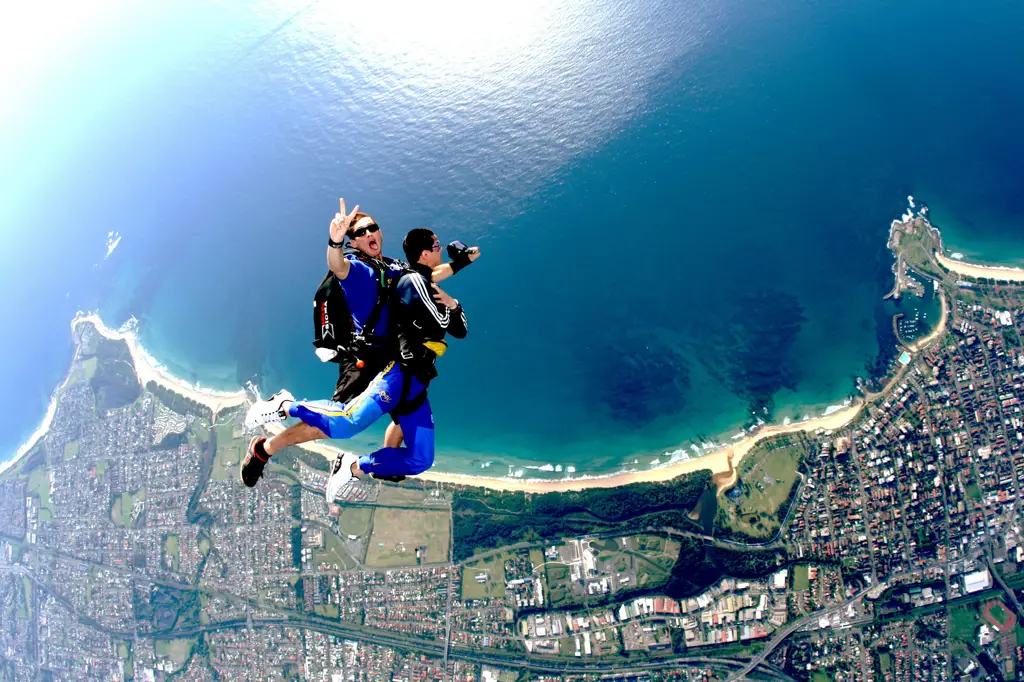 Seorang skydiver melakukan skydiving di atas pantai yang indah