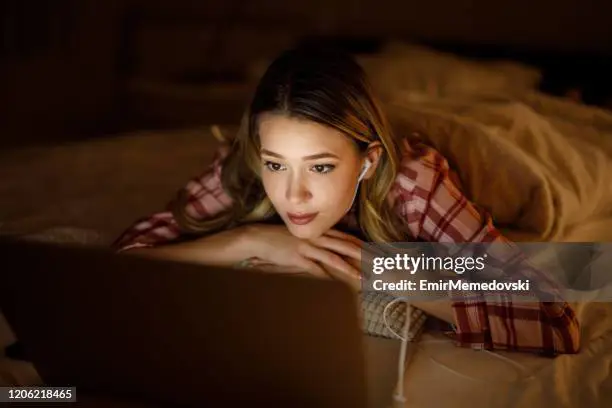 Menonton film bioskop gratis dengan nyaman di rumah Laptop menonton film di malam hari
