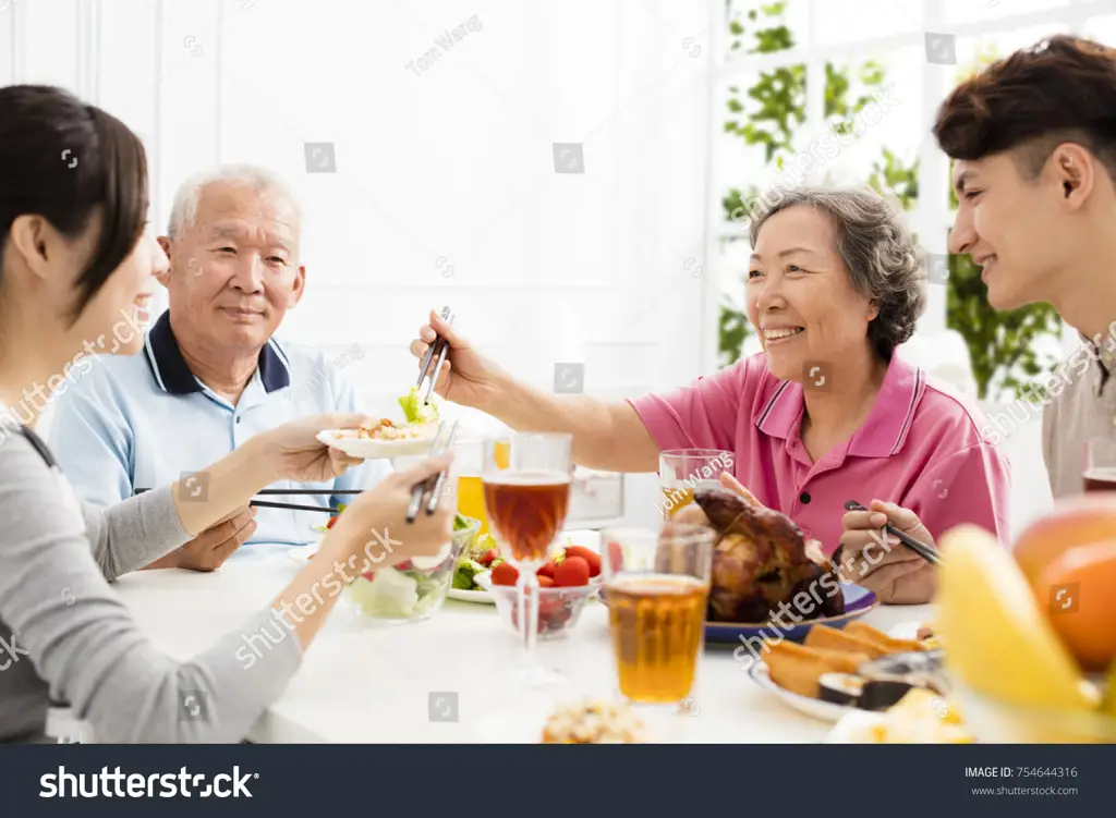 Keluarga sedang makan malam bersama, menunjukkan kehangatan dan kebersamaan keluarga